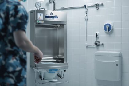 Moderner Steckbeckenspüler aus Edelstahl in einem sterilen Klinikaum